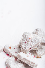  Valentine's day white coconut heart shaped cookies with red and pink heart sprinkles. Copy space