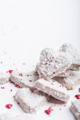  Valentine's day white coconut heart shaped cookies with red and pink heart sprinkles. Copy space