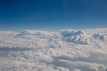 Naklejka na ściany i meble Skyline view above the clouds from airplane.