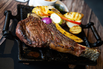 Grilled meat and vegetables. T-bone steak in a restaurant.