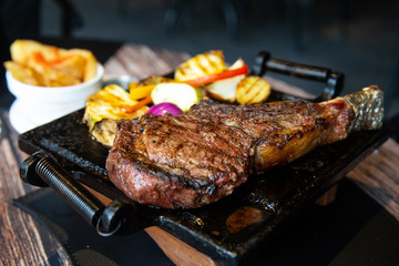 Grilled meat and vegetables. T-bone steak in a restaurant.