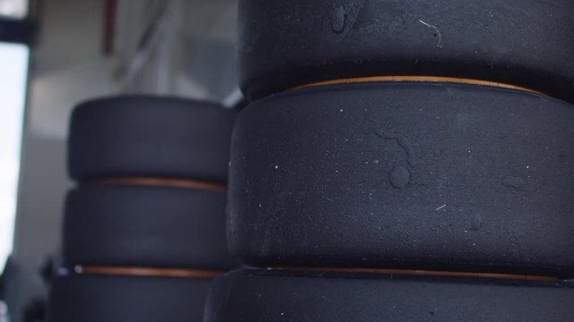 Racing tires in a garage ready for a pit stop - Rennreifen die in einer Garage f&uuml;r einen Boxenstopp bereitliegen 4k PRORES Footage