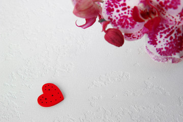  red heart and orchid flowers on a white textured background