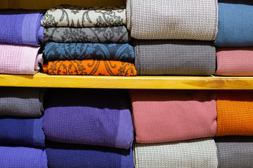 Piles of multicolored towels on the shelves.