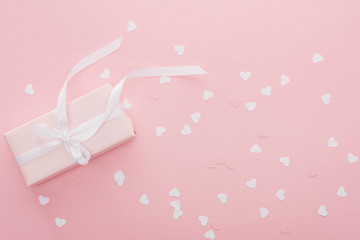 background of gift box and paper hearts isolated on pink
