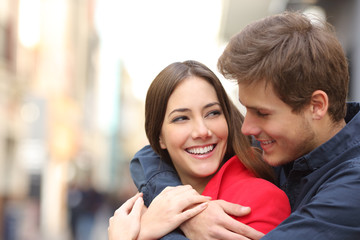 Happy girlfriend with perfect teeth being embraced