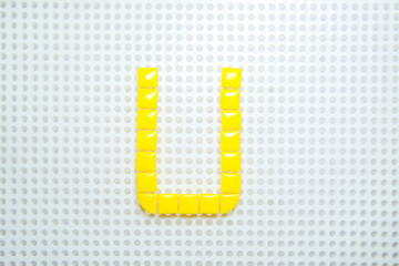 letter U created with children toys similar to pixels