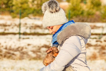 Woman playing with dog during winter