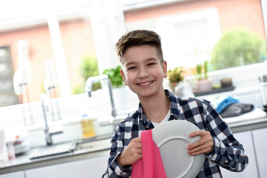Junge trocknet Teller ab
