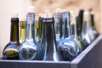Box with empty wine bottles in defocus, concept of drunkenness