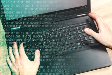Hands on laptop keyboard. Hacker concept with binary code. 