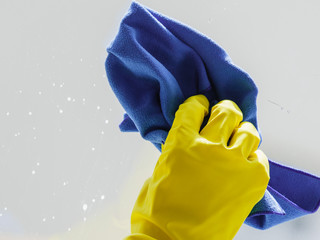 Person using cloth to clean window glass
