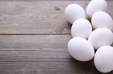 Chicken eggs on a grey background. Eggs on a brown wooden table