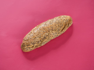 Bread with seeds on red background