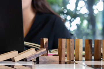 Growing business concept. Business Woman picking domino blocks for filling the missing dominus and protect domino to fail.