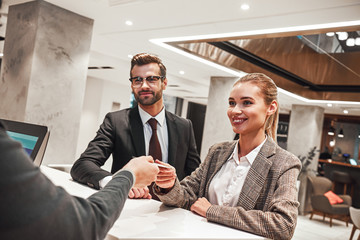 Couple on a business trip doing check-in at the hotel