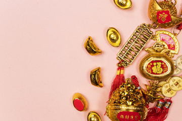 Fototapeta premium Happy Chinese New Year decoration on a pink background. Amulet of wealth and lucky. Calligraphy mean rich. Flat lay, Top view - Image.