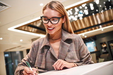 Businesswoman in hotel at reception or front office, fulfills her profile