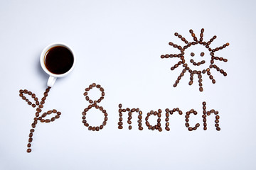 Congratulation of women on the international women's day on March 8.  A flower, asun and an inscription are made of coffee beans.  Close-up