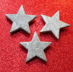 three silver stars on bright red glittery background