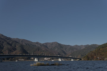 Bridge crossing lake Kawaguchi in an clear afternoon sky