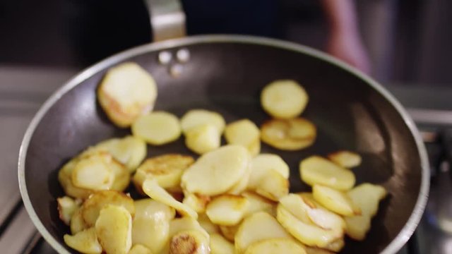 Fried potatoes are fried in a pan in the kitchen - Koch br&auml;t Bratkartoffeln in einer Pfanne in einer K&uuml;che an 4k PRORES Footage