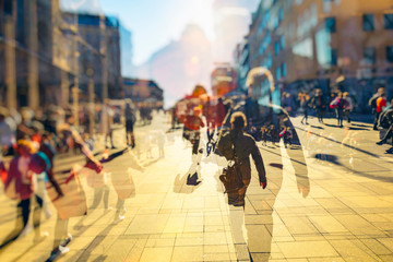 Crowd of anonymous people walking on busy city street 