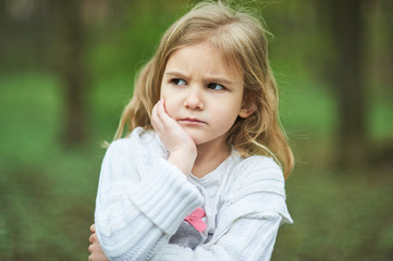 Portrait of sad unhappy little girl. Little sad child is lonesome. upset and distraught angry facial expression.