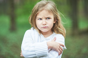 Portrait of sad unhappy little girl. Little sad child is lonesome. upset and distraught angry facial expression.