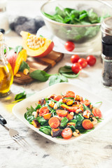 Roasted pumpkin salad with spinach, tomatoes and nuts