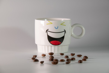 white cup with a pattern and coffee beans