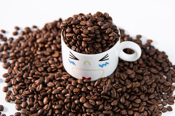 white cup with a pattern and coffee beans