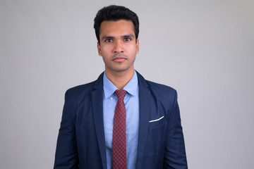 Portrait of young handsome Indian businessman wearing suit