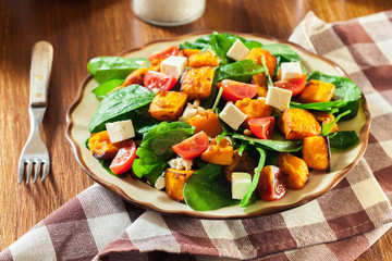 Roasted pumpkin salad with spinach, tomatoes and nuts