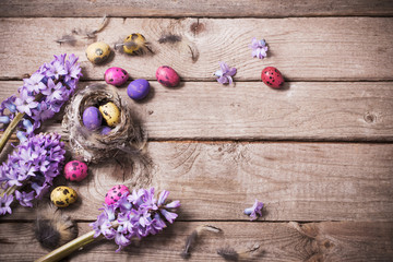 Easter eggs with spring flowers on wooden background