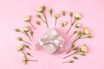 Beautiful mini roses with a pink gift box on a bright pink background. holidays. Valentine's Day. women's Day. top view.