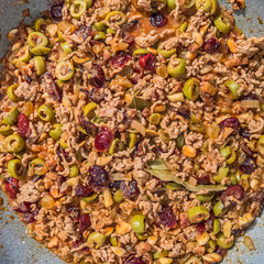 Stuffed with ground meat for Christmas dinner with olives, raisins, cranberries, walnuts, almonds, bay leaf and spices. Homemade traditional food concept
