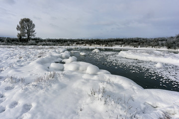Winter landscape by a river in the sunset