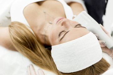 Beautiful long-haired girl practicing facial cleansing in a beauty salon caring for her skin