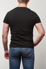 back view of man in black t-shirt with copy space isolated on grey