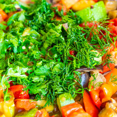 Vegetable stew sprinkled with chopped parsley and dill close-up