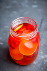 Red cocktail with cherry and lime in jar on the rustic background. Selective focus. Shallow depth of field.