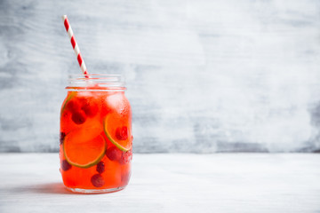 Red cocktail with cherry and lime in jar on the rustic background. Selective focus. Shallow depth of field.