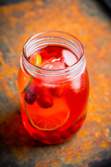 Red cocktail with cherry and lime in jar on the rustic background. Selective focus. Shallow depth of field.