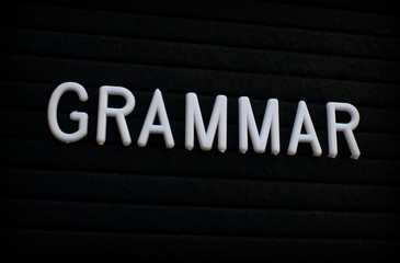 The word Grammar in white plastic letters on a felt notice board