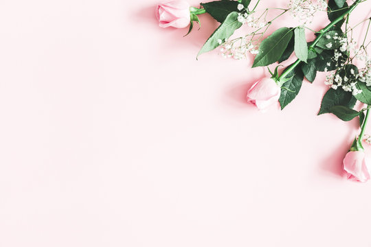 Flowers composition. Rose and gypsophila flowers on pastel pink background. Valentines day, mothers day, womens day concept. Flat lay, top view, copy space