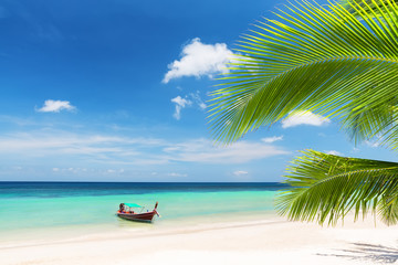 Fototapeta na wymiar Thai traditional wooden longtail boat and beautiful sand beach