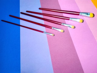 Paint brushes on a background of colored paper
