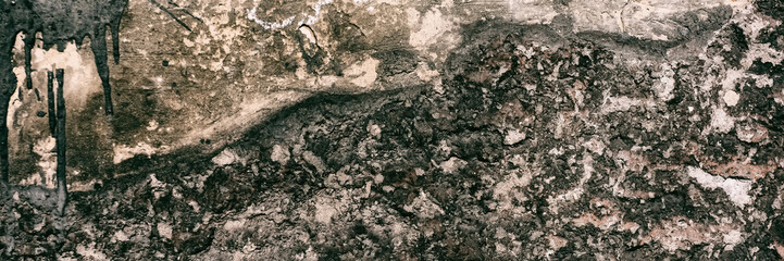 Brick wall surface covered with old crumbling cement plaster.