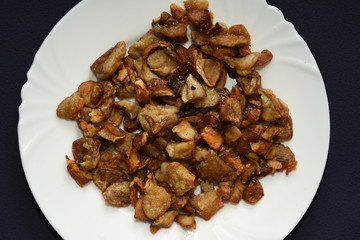 mushrooms fried with goldene apples sliced on a white plate